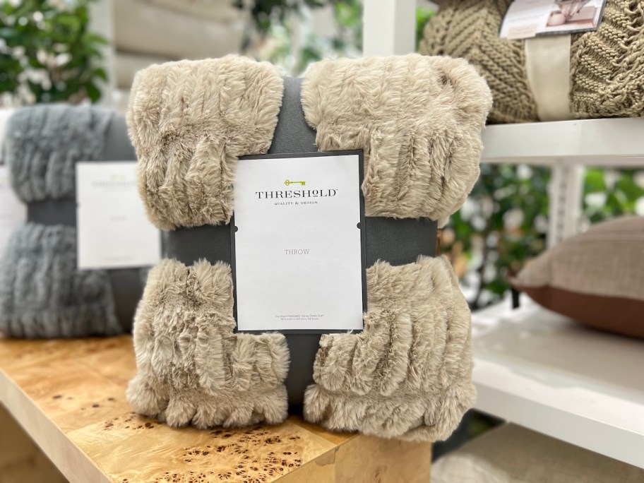 brown ruched faux rabbit fur throw in packaging on store display