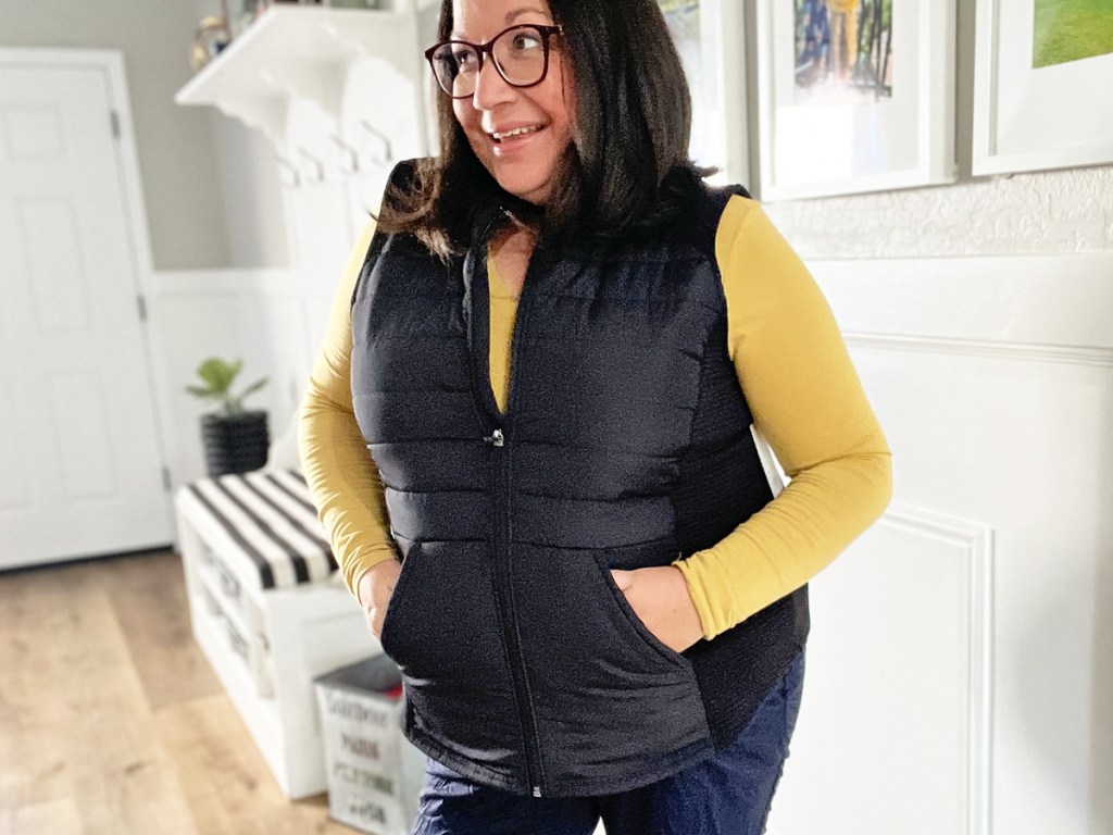 woman wearing yellow long sleeve top with black vest