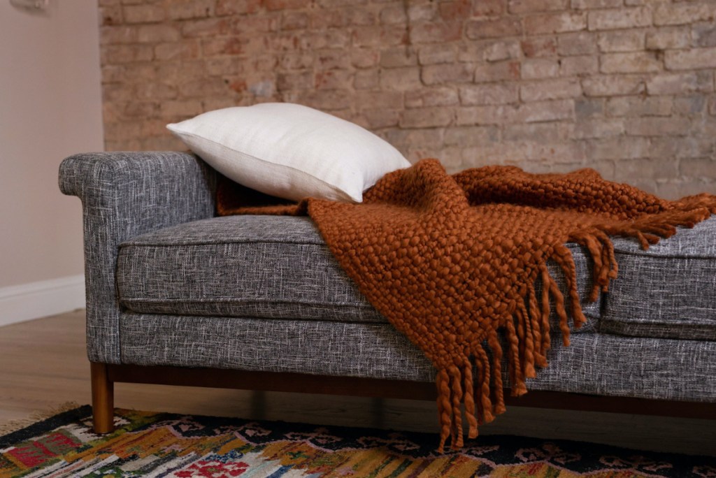 close up of pillow and throw blanket on sleeper sofa