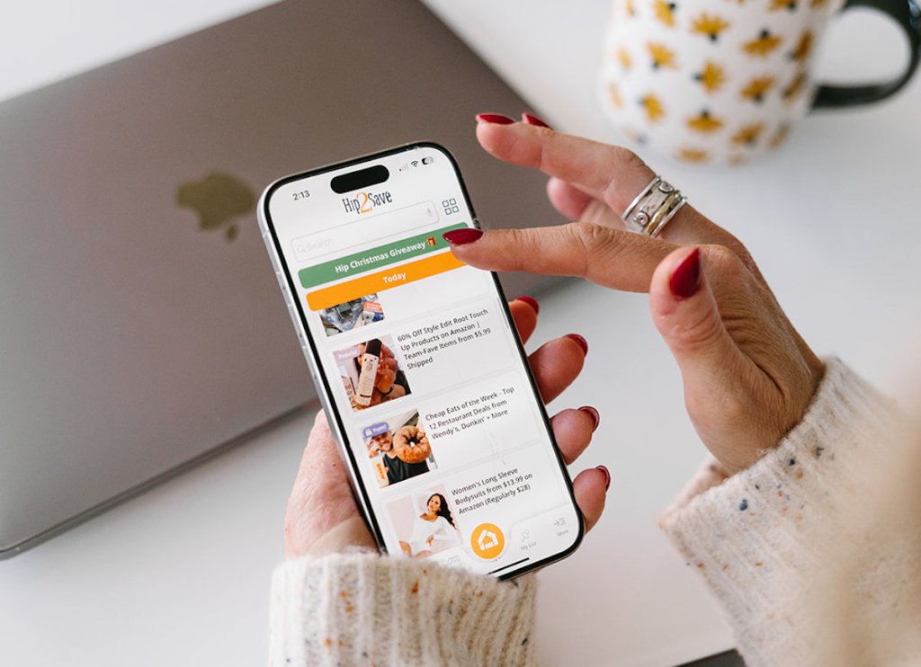 person holding mobile phone with hip2save app on screen
