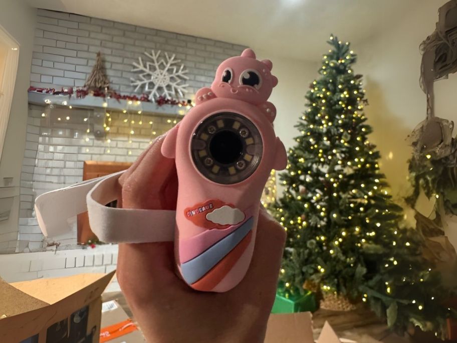 microscope camera being held by hand in front of christmas tree