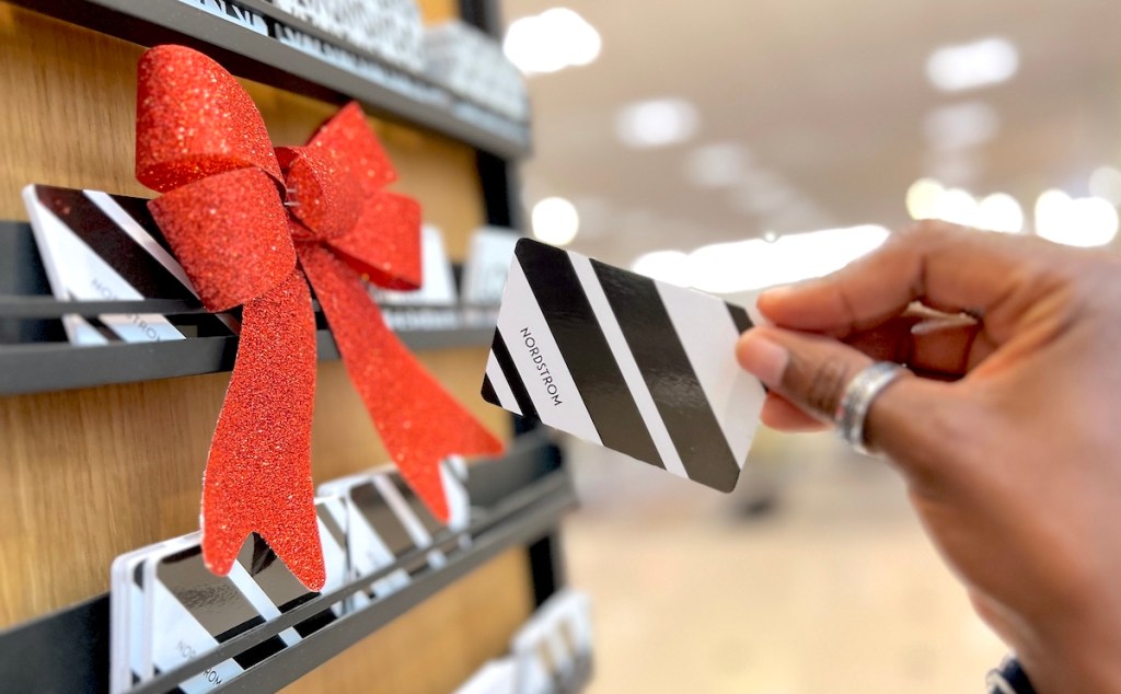 hand holding a black and white stripe nordstrom gift card in store