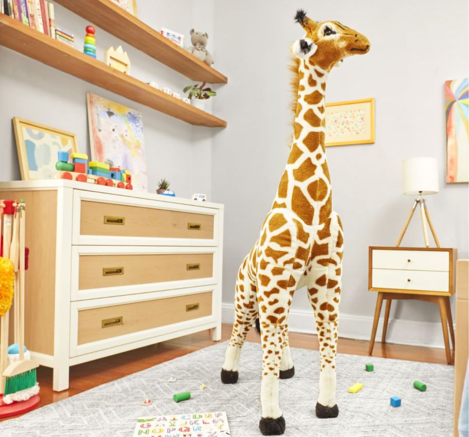 a giant plush giraffe in a kids room. 