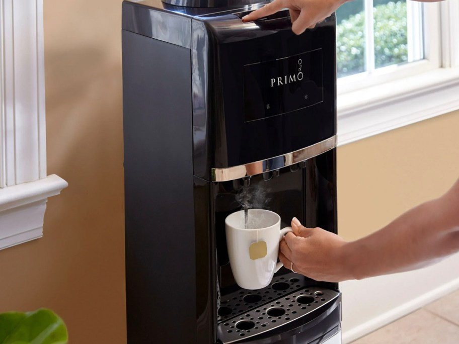 black and stainless steel water dispenser with coffee mug 