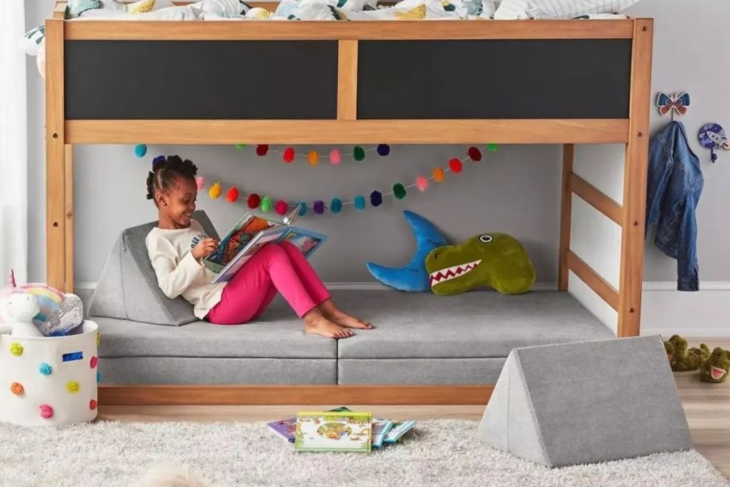 girl sitting on gray sams club explorer sofa under bunk bed