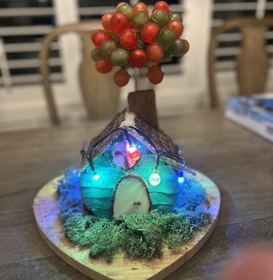 gingerbread house with blue lights and balloon from up house