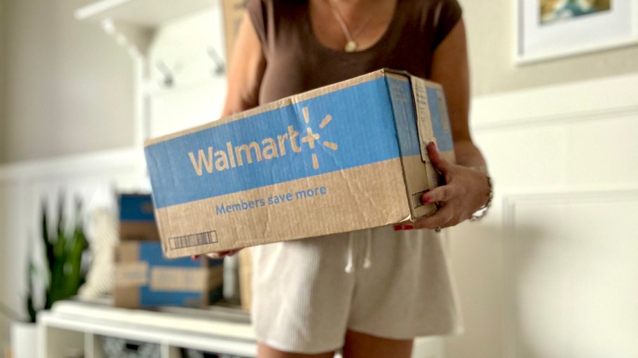 woman holding walmart plus box in hallway