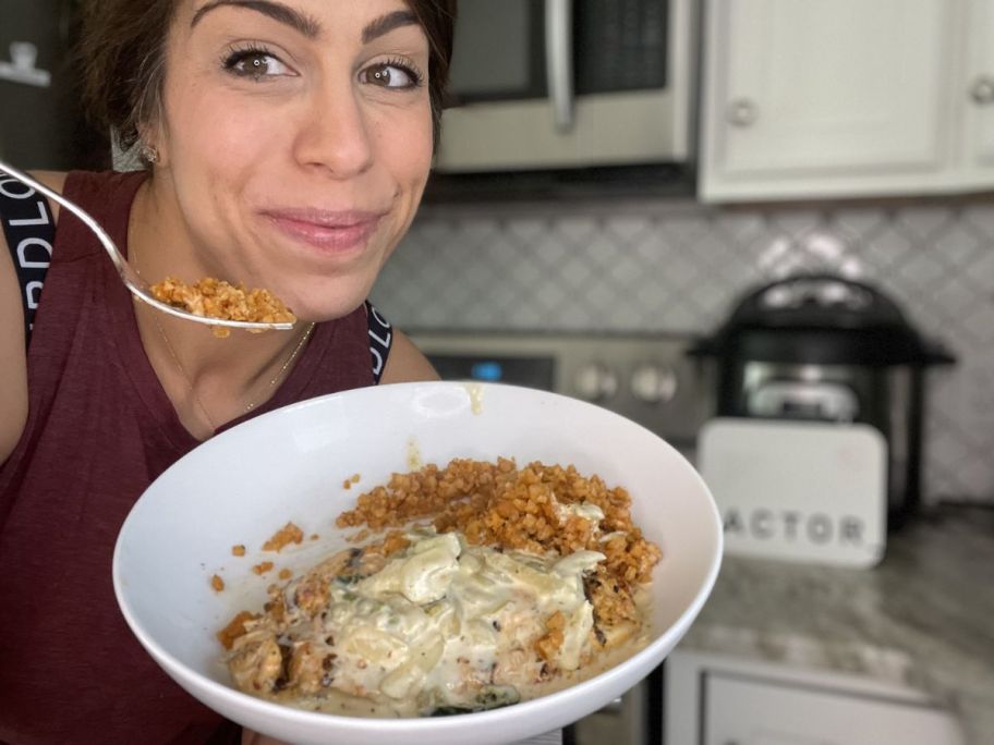 woman holding a plate with a Factor meal on it