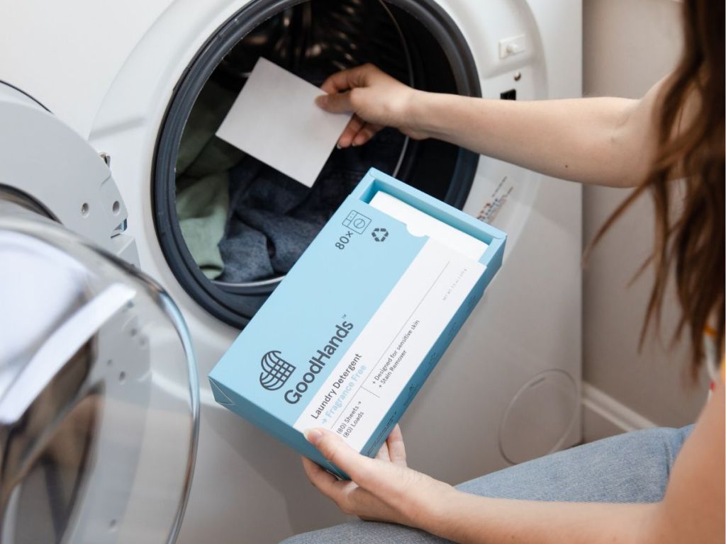 woman putting a Good Hands Laundry Detergent Sheet in the wash