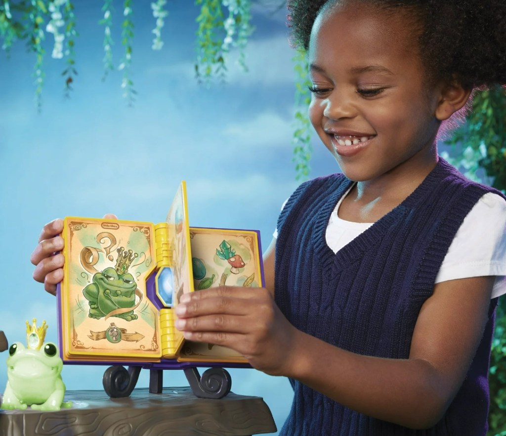 girl playing with a Little Tikes Magic Workshop Spellbook