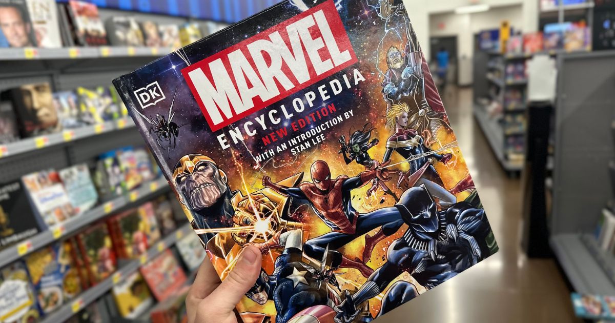 A hand holding a copy of the Marvel onlineics encyclopedia