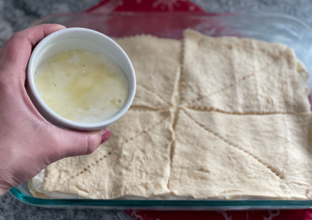 Pouring butter over crescent rolls