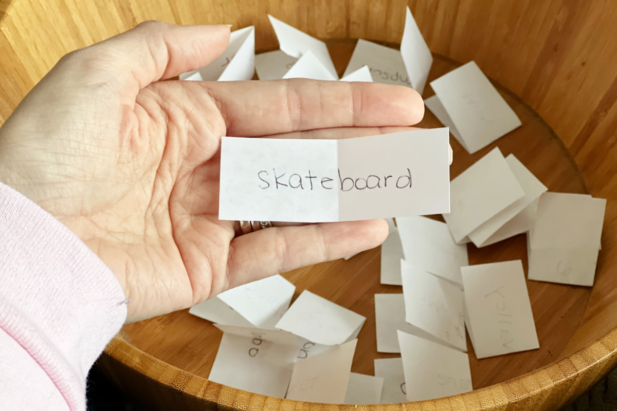 hand holding a salad bowl game clue while demonstrating the salad bowl game instructions