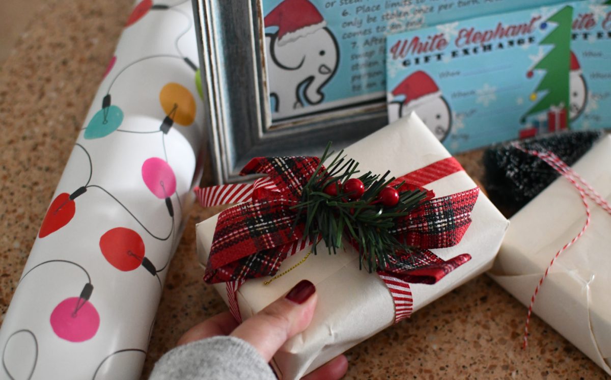 Hand placing a white elephant gift on a table