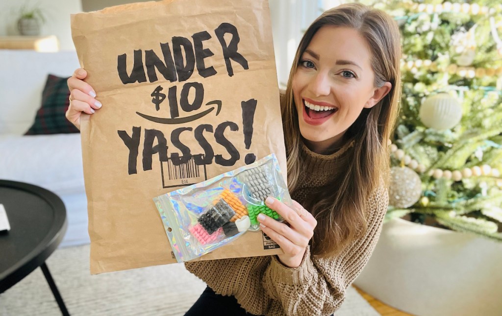 woman holding amazon bag with under $10 and bag of cord protectors