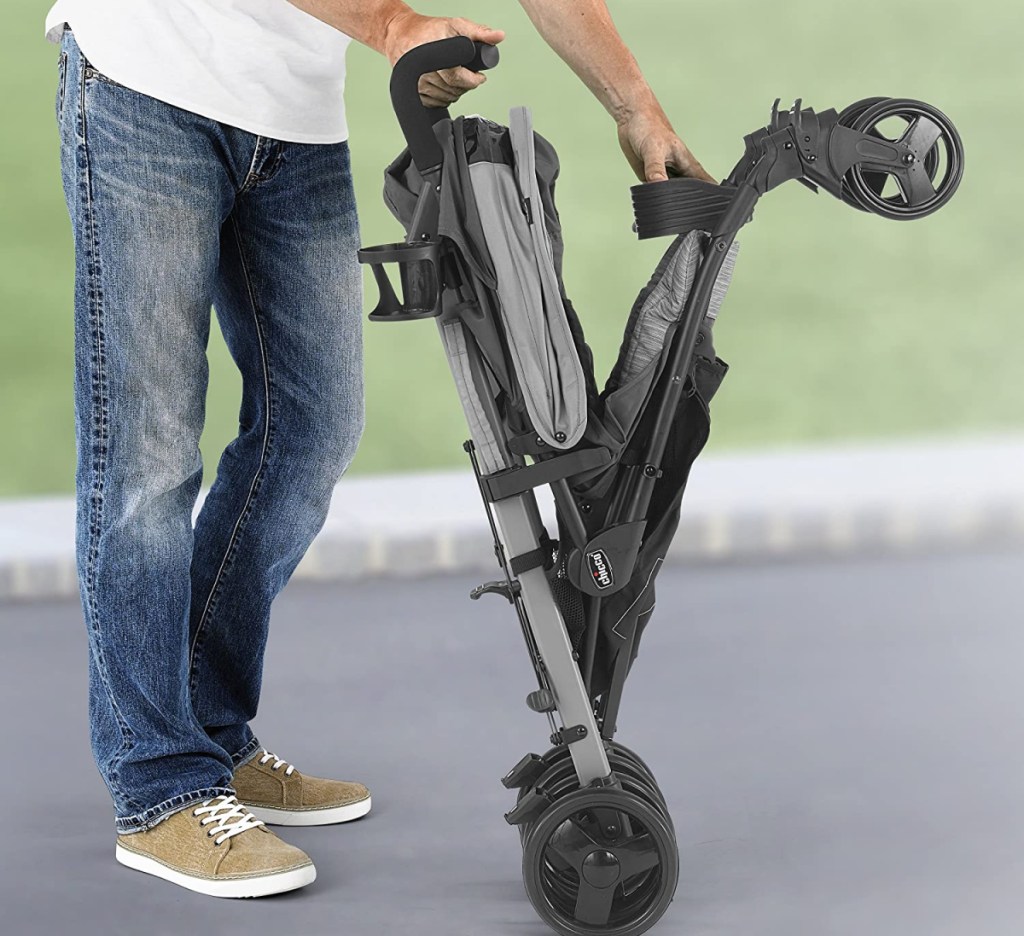 man folding up a liteway chicco stroller outside