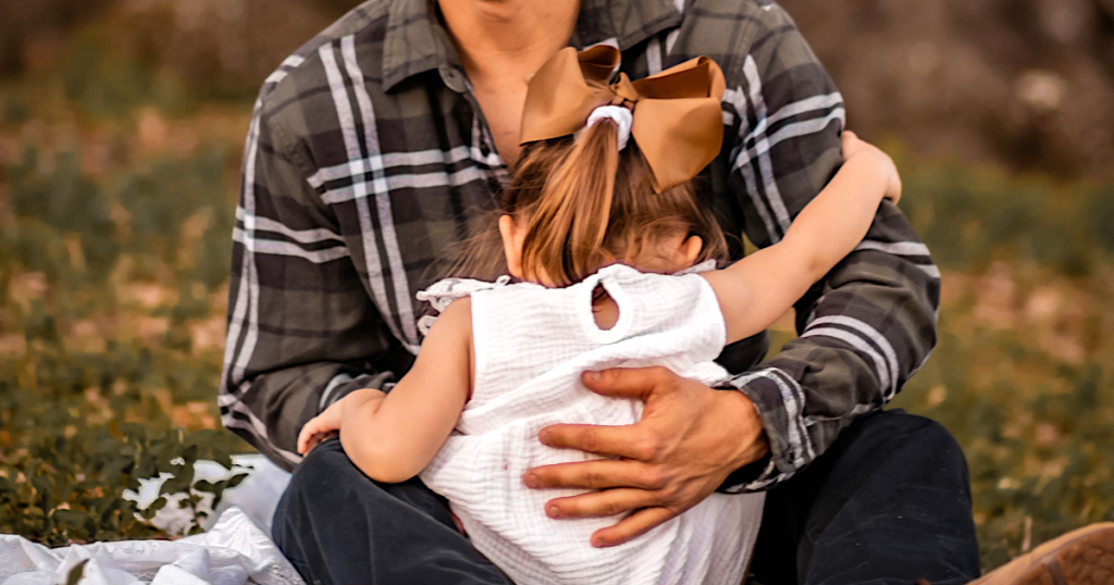 man holding child wearing flannel shirt 