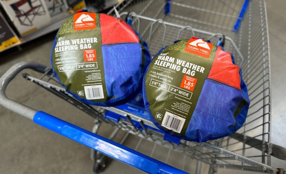 two ozark trail youth sleeping bags in blue in a walmart cart