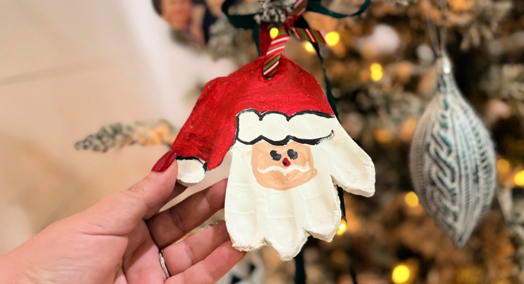 santa handprint ornament hanging on the tree 