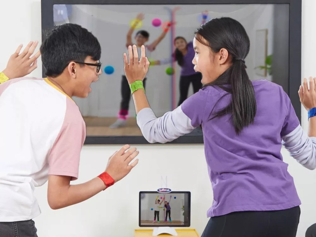 two kids playing Twister Air in front of a TV