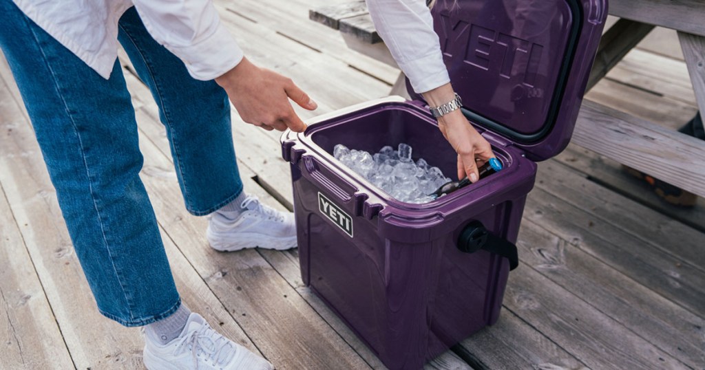 woman getting something out of cooler