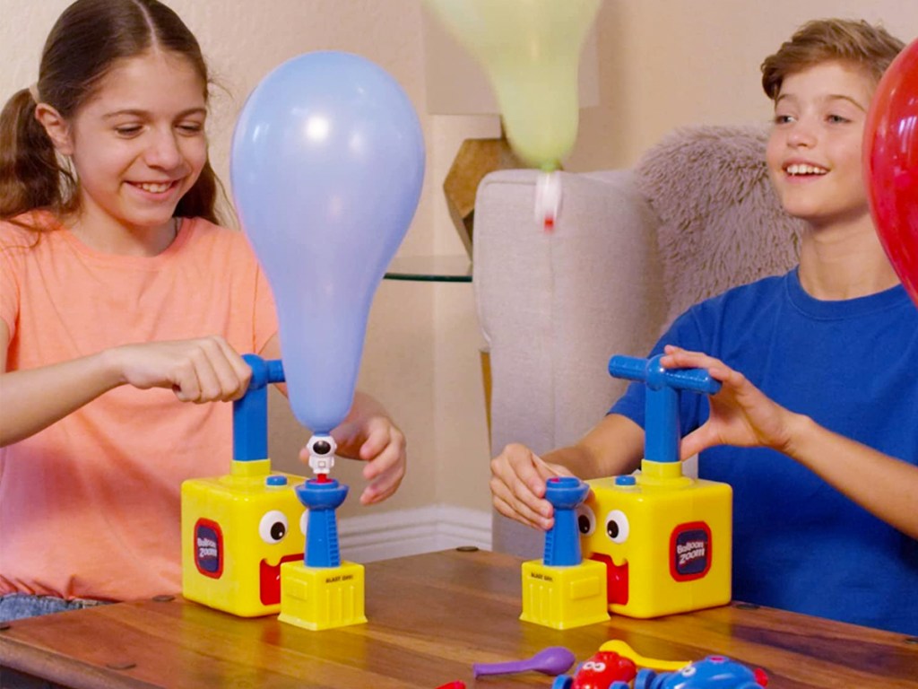 two kids playing with balloon zoom toys