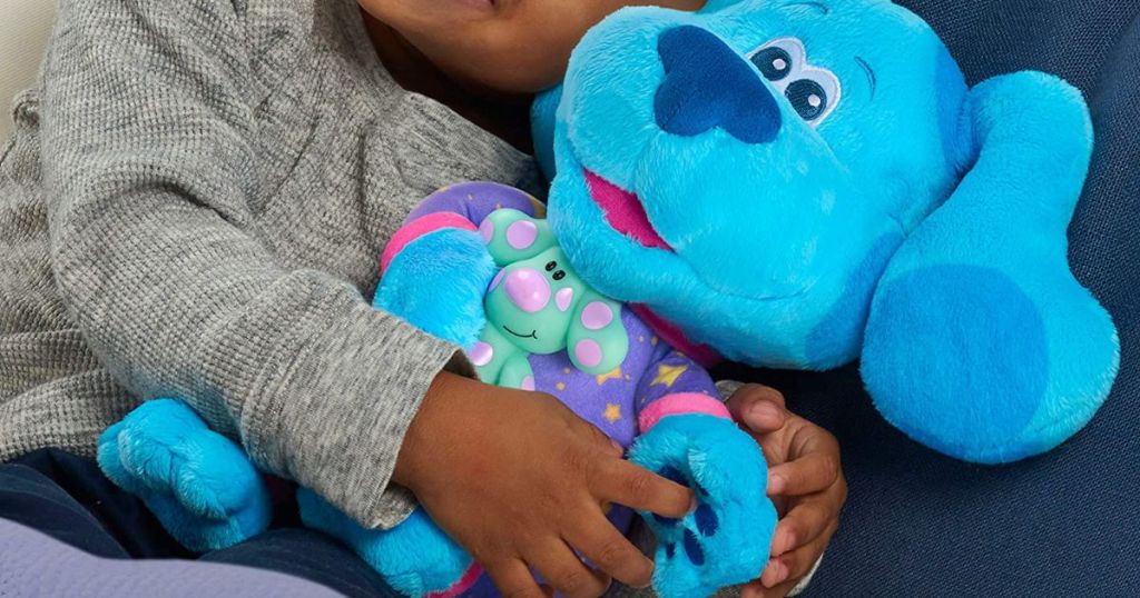 A child holding a plush blue dog