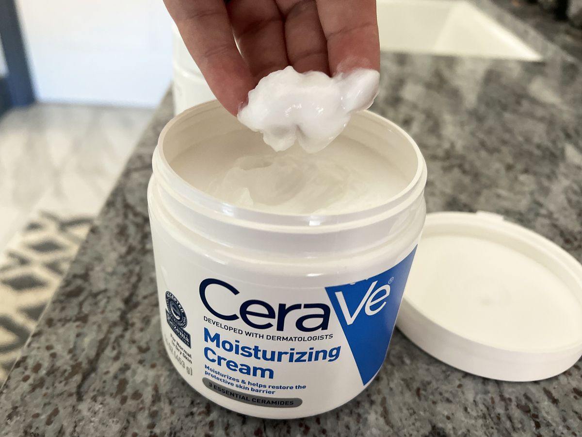 hand grabbing cerave cream from jar