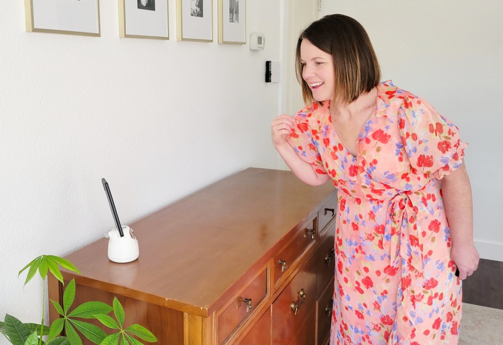 woman in dress looking at phone in a white tripod