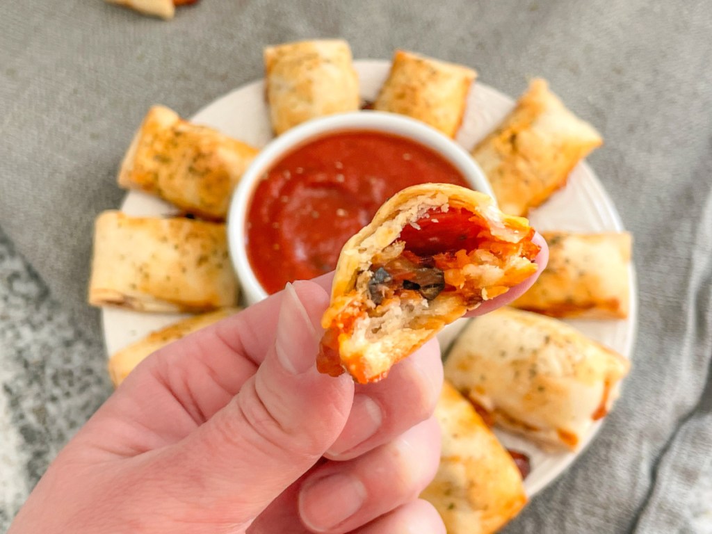 holding a homemade pizza bite with a bite out of it