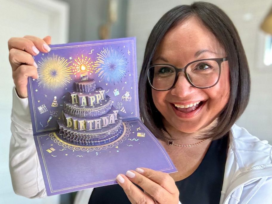 Woman holding a pop up birthday card with fireworkds