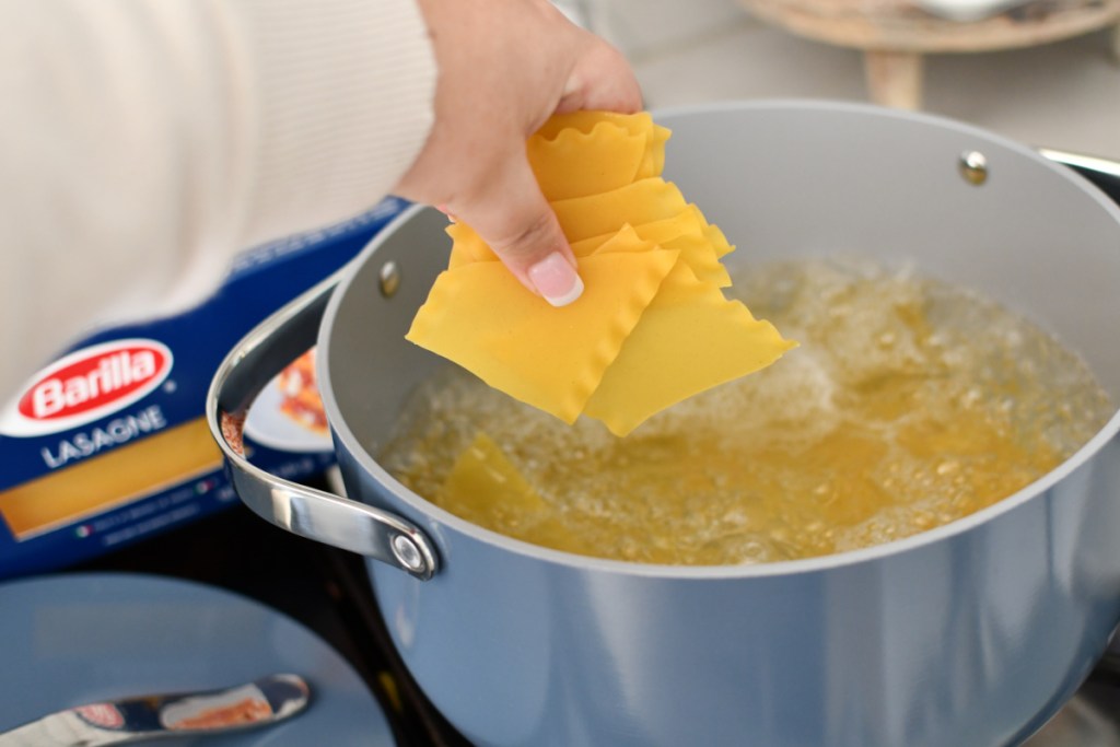 Putting lasagna into a pot of boiling water in order to make lasagna soup