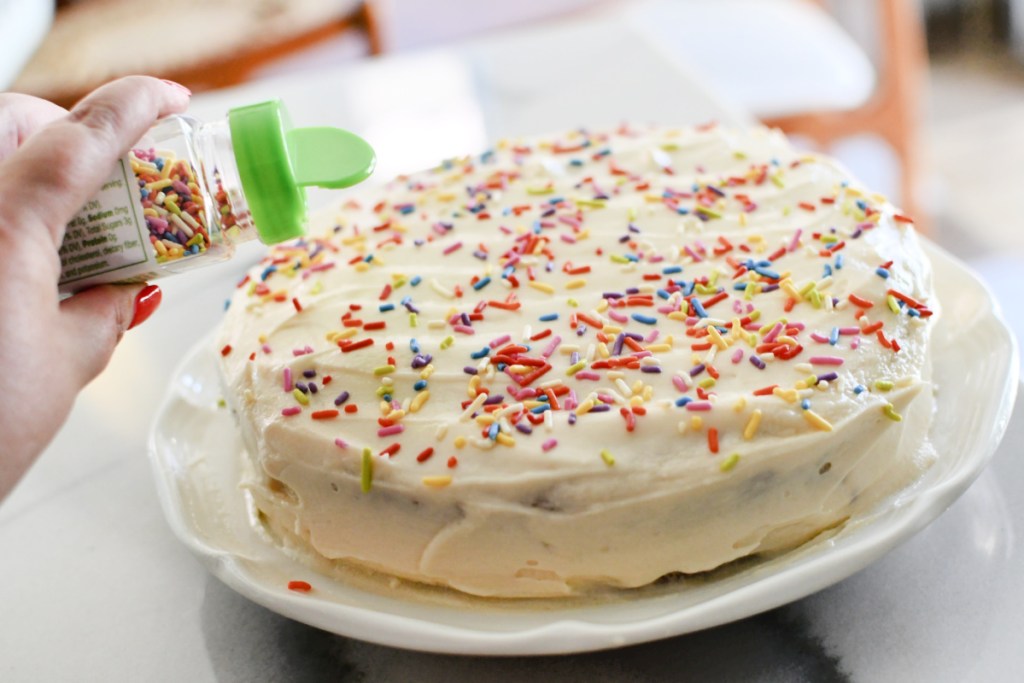 adding vegan sprinkles to a cake