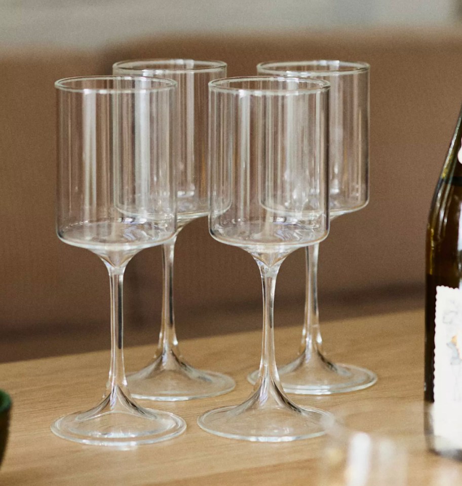 set of four clear wine glasses on beige counter