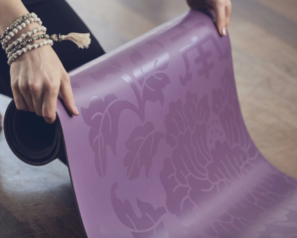 purple yoga mat in hands