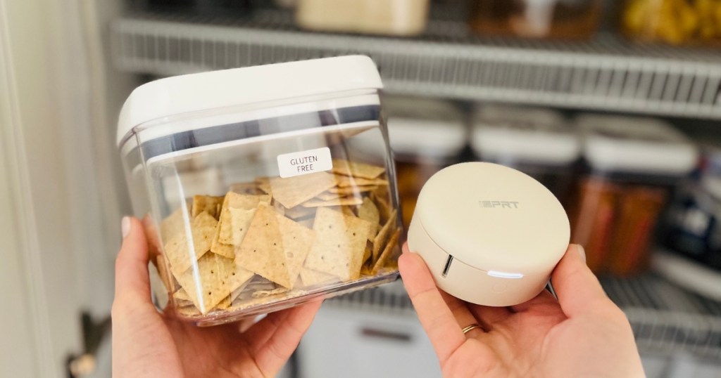 Hand holding a label maker next to a container of crackers