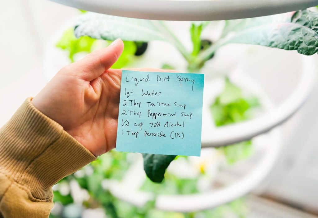 hand holding a post it note with liquid dirt recipe