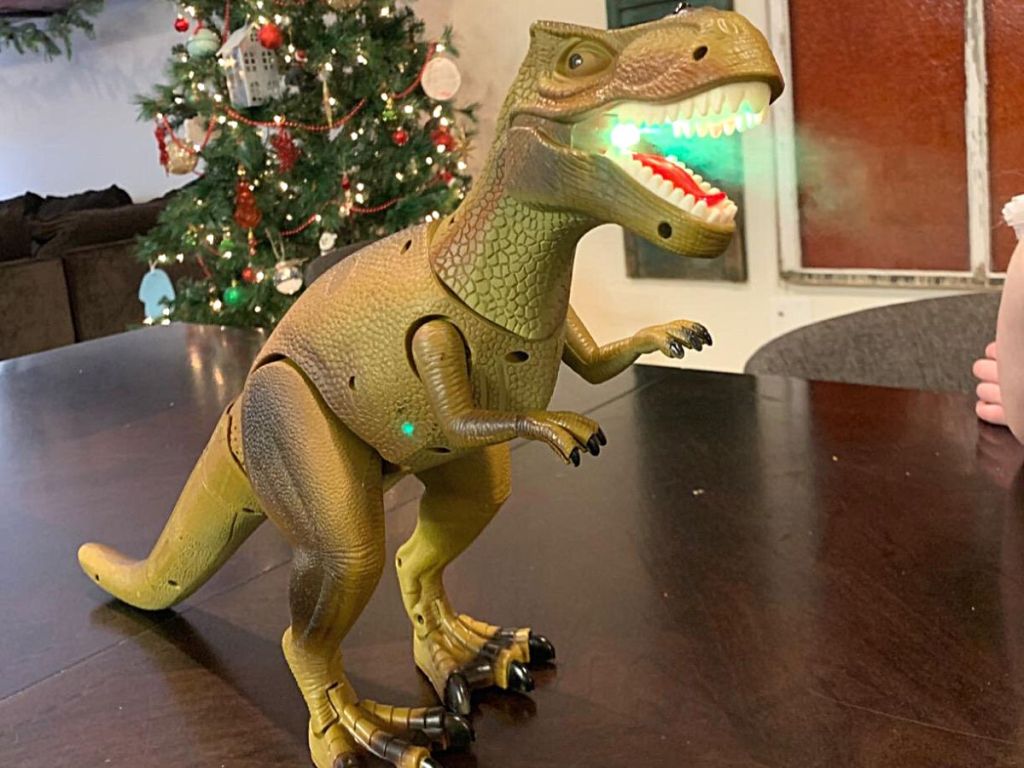 dino toy with green light in mouth showing mist