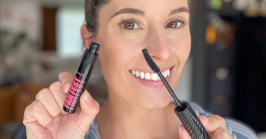 Woman holding Benefit Fan Fest Mascara after using it on her eye lashes