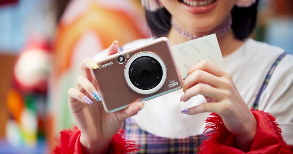 woman printing a photo from a mini canon printer