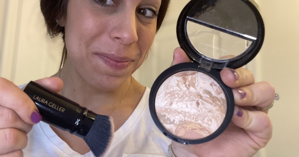 woman with Laura Geller balancing foundation and brush