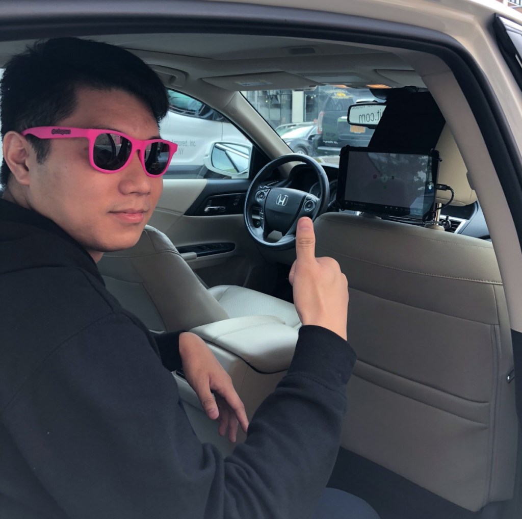 A man giving a thumbs up sign to the Play Octopus tablet placed in his rideshare