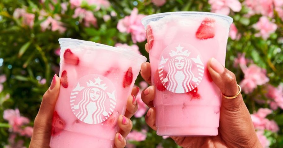 two people holding up their Starbucks iced pink drinks