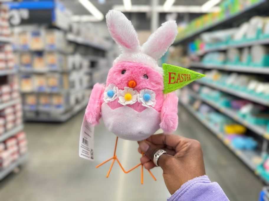 pink Easter chick bird with bunny rabbit ears and flowers in person's hand