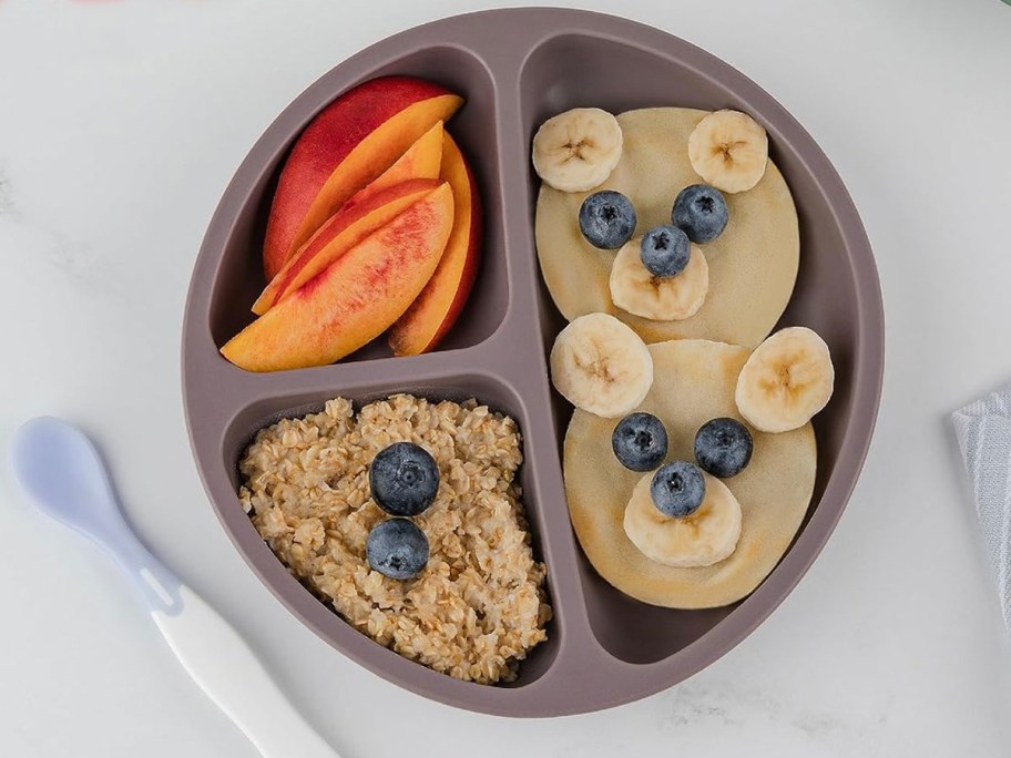 purple plate with bananas, granola, and peaches