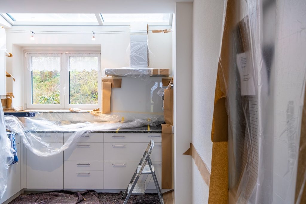 kitchen under renovation with plastic on counters 