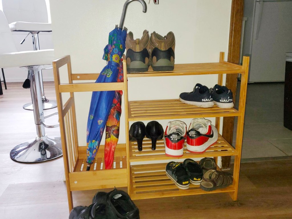 honey can do shelf with shoes and umbrella