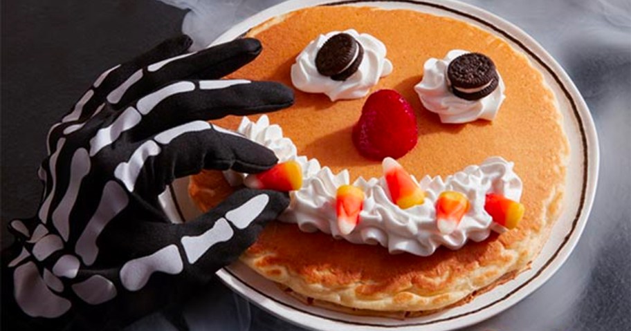 ihop scary face pancake with skeleton hand adding candy corn to face