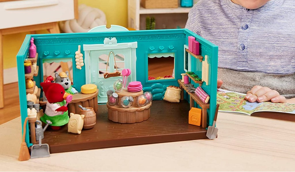 boy playing with a lil woodzeez animal playset general store design