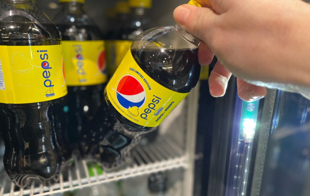 hand tipping a bottle of limited edition peeps pepsi off a cooler shelf